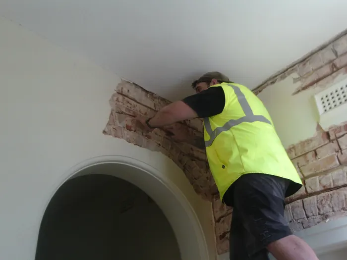 Bowsan installer carrying out Helifix stitching and beaming inside a house